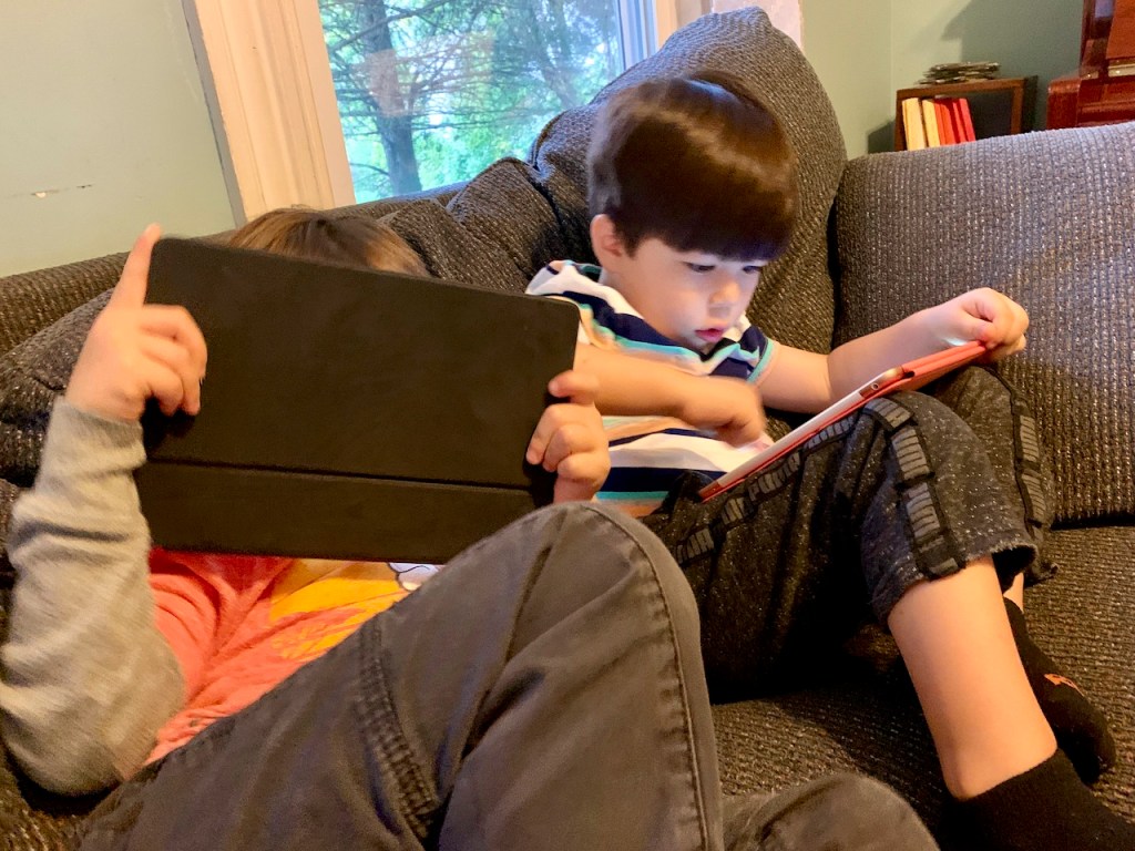 Two kids giving iPads deep attention